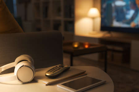 Modern living room interior with television screen in the background, selective focus