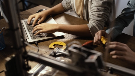 Students using a 3D printer and a laptop, they are printing plastic prototypesの写真素材