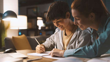 Young happy students doing homework together at homeの写真素材