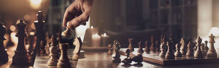 Chess game: luxury wooden chess set and player moving pieces on the chessboard, strategy and tactics games, photo collage bannerの写真素材