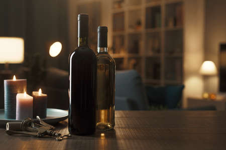 Luxury red and white wine bottles on a table in the living room at home, wine tasting conceptの写真素材
