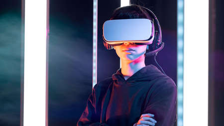 Cool teenager wearing a VR headset and experiencing virtual reality, technology and gaming concept