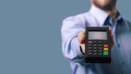 Businessman showing a POS terminal, electronic payments conceptの写真素材