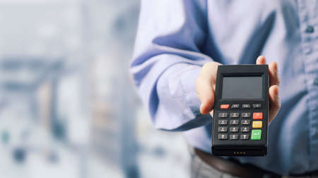 Businessman showing a POS terminal, electronic payments conceptの写真素材