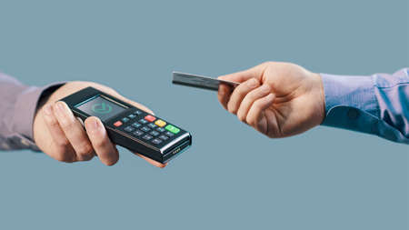 Customer paying with a contactless credit card, electronic payments concept