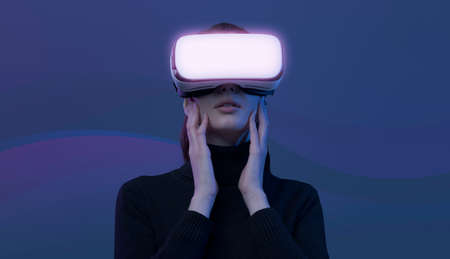 Woman wearing VR headset and interacting with virtual reality, she is amazed and excited