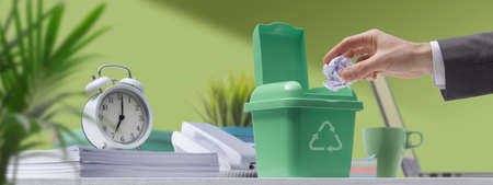 Corporate businessman putting crumpled paper in a recycling bin, waste disposal and recycling...