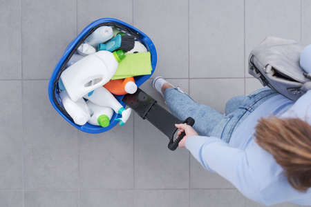 Woman pulling a shopping basket full of cleaning products at the store, top viewの写真素材