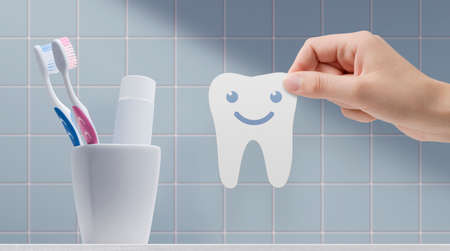 Woman holding a dental hygiene sticker with cute smiling characterの写真素材