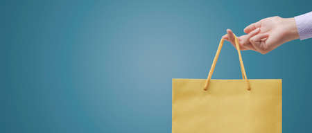 Woman holding a shopping bag, sales and shopping banner with copy spaceの写真素材