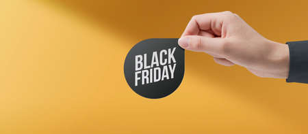 Hand holding a Black Friday promotional label, sales and offers conceptの写真素材