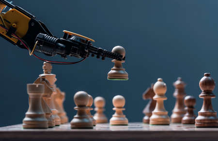 Robot moving chess pieces on chessboard, close upの写真素材