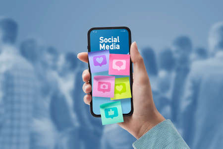 Woman connecting with social media online: sticky notes with icons on smartphone screen, POV shot