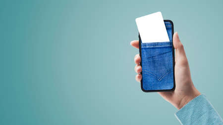 Hand holding a smartphone with a jeans pocket and blank card on the display, blank copy space, POV...
