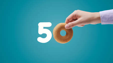 Number 50 written with donut shaped cookie, blank copy space, isolatedの写真素材
