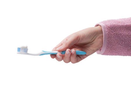 Woman holding a toothbrush with toothpaste on white backgroundの写真素材