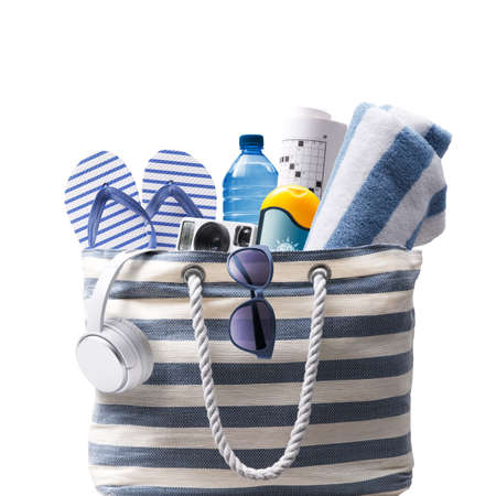 Striped beach bag with accessories, Isolated on white background, summer vacations concept