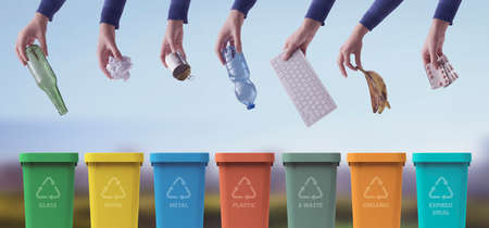 Hands putting waste in different trash bins, separate waste collection and recycling conceptの写真素材