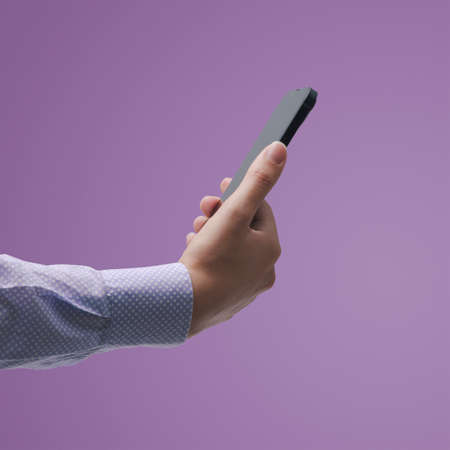 Woman holding a smartphone and connecting online, she is chatting and using apps, blank copy spaceの写真素材