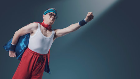 Funny superhero flying with clenched fist, blank copy spaceの写真素材