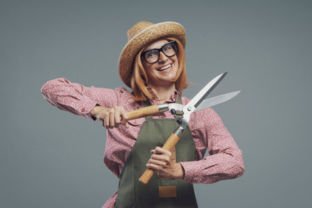 Confident smiling woman posing with hedge shears, gardening and hobbies conceptの写真素材
