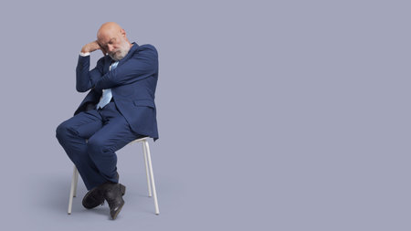 Senior corporate businessman sitting on a chair and sleepingの写真素材