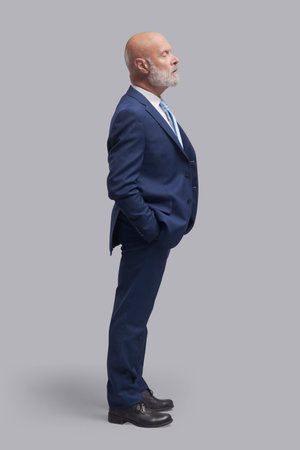 Corporate businessman standing and waiting, side viewの写真素材