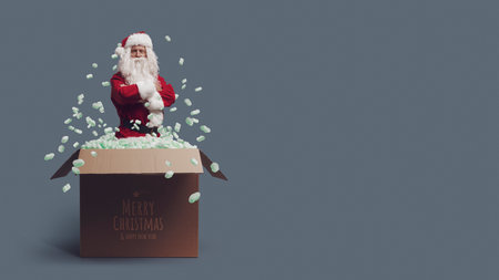 Happy Santa Claus coming out from a delivery box and Christmas wishes, blank copy spaceの写真素材
