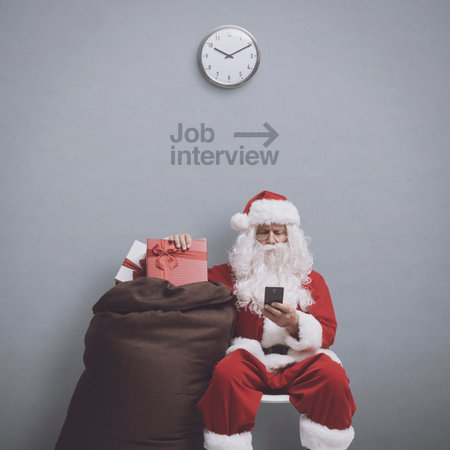 Santa Claus waiting for a job interview, he is connecting with a smartphone and holding a sack with giftsの写真素材