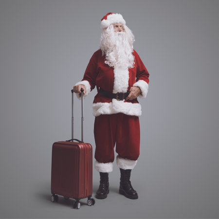 Traveling Santa Claus holding a trolley bag and waiting, he is leaving at Christmasの写真素材