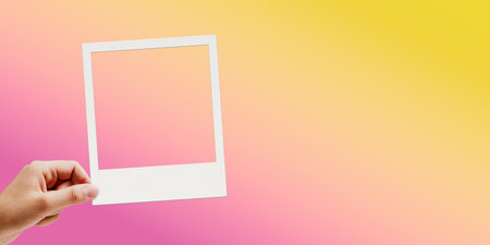 Female hand holding a vintage instant photo, copy spaceの写真素材