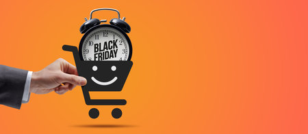 Customer holding a shopping cart icon with alarm clock inside: online shopping and Black Friday sale conceptの写真素材