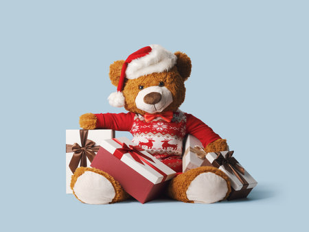 Cute teddy bear wearing a Santa hat and Christmas gifts, holidays and celebrations conceptの写真素材