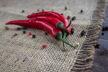 Chili pepper lies on a sackcloth on a wooden table.の写真素材