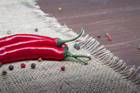 Chili pepper lies on a sackcloth on a wooden table.の写真素材