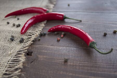 Chili pepper lies on a sackcloth on a wooden table.の写真素材