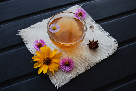 Flower tea in a transparent glass cup on the black table. Healing tea.の写真素材