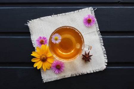 Flower tea in a transparent glass cup on the black table. Healing tea.の写真素材