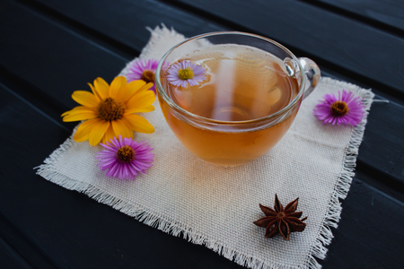Flower tea in a transparent glass cup on the black table. Healing tea.の写真素材