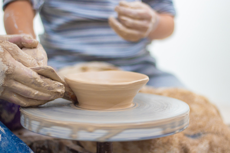 Ware from clay. The teacher helps the student to make clay dishesの写真素材