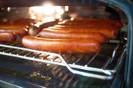 Cooking sausages in the oven. Fast food street. Fried sausages