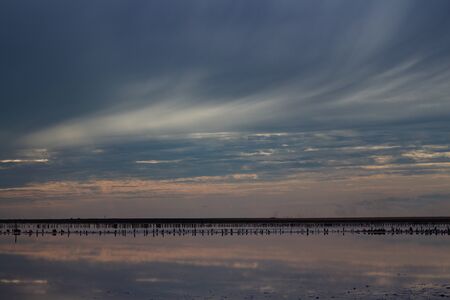 Amazingly beautiful clouds. Reflections of the sky in the water. Photo taken after sunsetの写真素材
