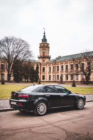 Kiev, Ukraine - January 26, 2020. Alfa Romeo of black color against the background of the Kiev Polytechnic Institute.のeditorial素材
