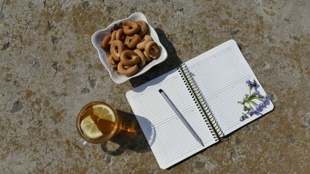 Working environment. Near the notebook is a cup of tea and a plate with bagels.の写真素材