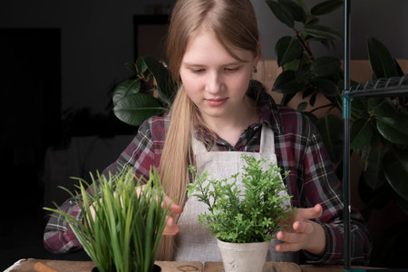 A girl takes care of plants. The concept of planting plants, caring for plants, growing seedlings.の写真素材