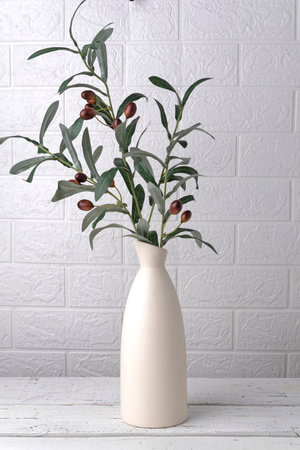 Olive branch with olives in an empty bottle, vase on a white backgroundの写真素材