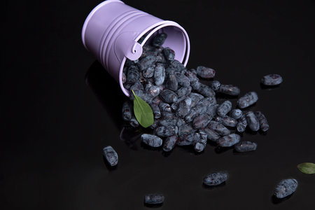 blueberries poured out of a bucket on a table and a dark backgroundの写真素材