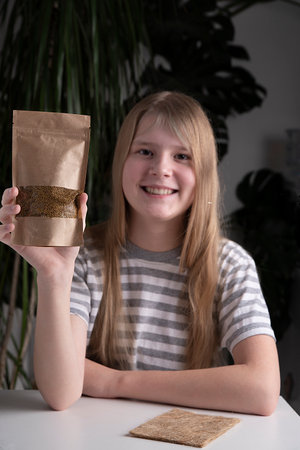 Happy girl holding microgreen mat. The concept of a healthy lifestyle, natural greens without GMOs, without pesticides, without fertilizers. close-up, plant careの写真素材