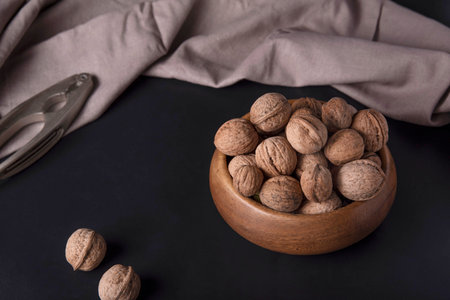 Walnuts are in a cup. Dark background