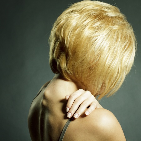 Fashion portrait of young beautiful woman with blond hair looking down sadlyの写真素材